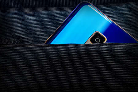 blue mobile phone with a camera in a bag pocketの写真素材