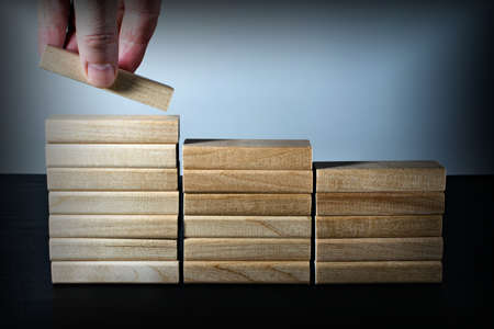 Hand stacking wooden blocks in the form of stairs. Business concept for process growth success.の写真素材
