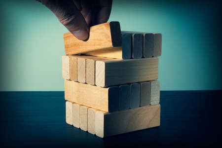 A hand places wooden blocks in a stack. Business concept for process growth success.の写真素材