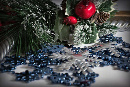 Christmas background with fir branches, cones, a bunch of red berries, candles and snowflakes.の写真素材