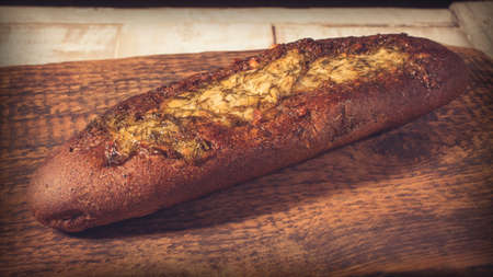Rye baguette with garlic sauce and dill on a dark textured wooden surfaceの写真素材