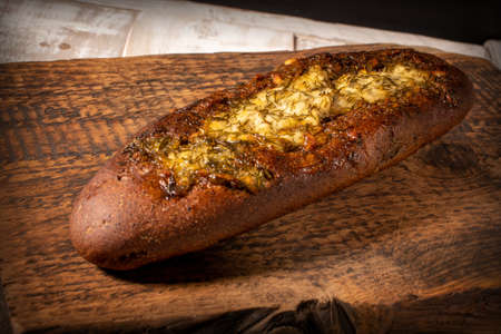 Rye baguette with garlic sauce and dill on a dark textured wooden surfaceの写真素材