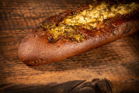 Rye baguette with garlic sauce and dill on a dark textured wooden surfaceの写真素材
