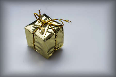 Gold gift box with gold thread on a white backgroundの写真素材