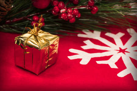 Christmas decorations and gifts on a red background with a white snowflakeの写真素材