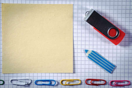 Notebook paper, notepad, stationery and flash memory on a white backgroundの写真素材