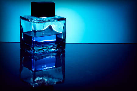 Background with bottle of perfume with blue liquid, backlit. Copy spaceの写真素材