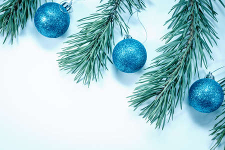 Christmas blue balls and pine branches laid out on a white background. Winter holiday concept. View from above. Copy spaceの写真素材