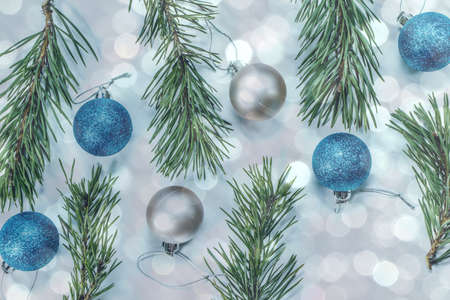 Christmas background with pine branches, bright balls and sebristine bokeh. Holiday concept. View...