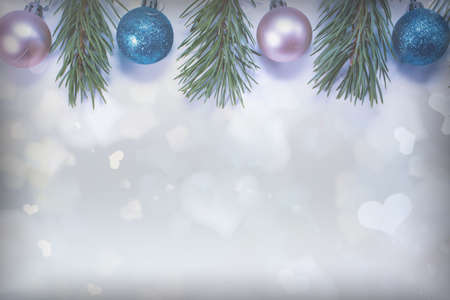 Christmas background with pine branches, balls and silver bokeh in the form of hearts. Holiday concept. View from aboveの写真素材