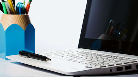 Open laptop, organizer and black pen on a white background. Back light. Business conceptの写真素材