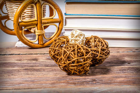 Rattan balls on a wooden table on the background of books and wicker products from willowの写真素材