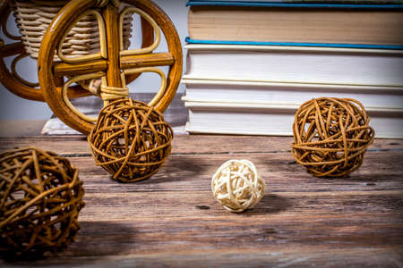 Rattan balls on a wooden table on the background of books and wicker products from willowの写真素材