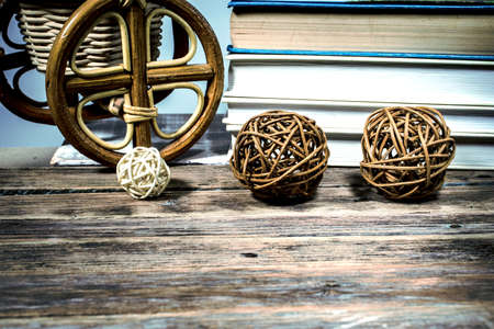 Rattan balls on a wooden table on the background of books and wicker products from willowの写真素材