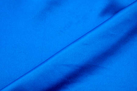Dark blue colored fabric background. Beautiful satin silk textured fabric.の写真素材