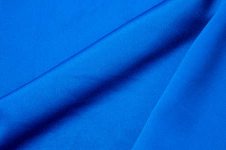 Dark blue colored fabric background. Beautiful satin silk textured fabric.の写真素材