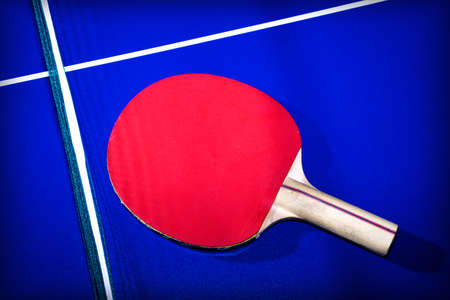 Red table tennis racket on blue table backgroundの写真素材