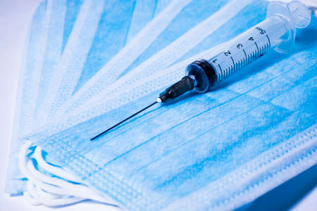 Syringe for injection on the background of medical masksの写真素材