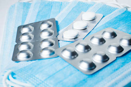pills in blister pack isolated on medical masks backgroundの写真素材
