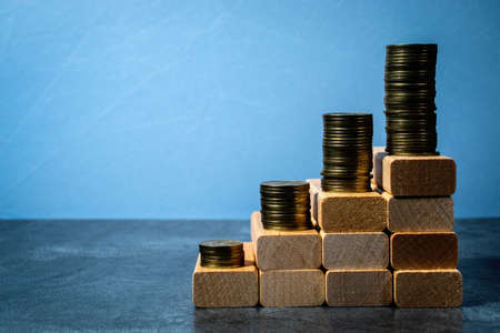 The concept of economic planning. Piles of coins on wooden blocks in the form of steps. The idea of...