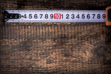 measuring tape on wooden background