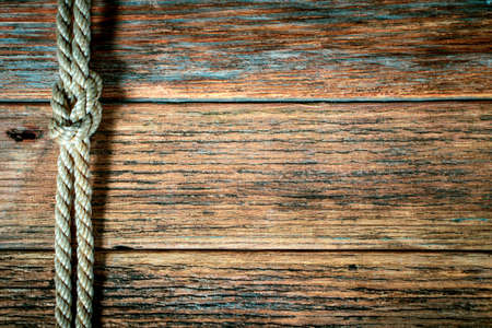 Ship rope knot on old wooden texture backgroundの写真素材
