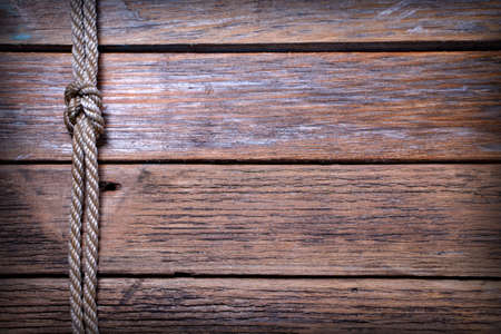 Ship rope knot on old wooden texture backgroundの写真素材
