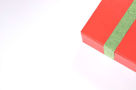 Closeup gift red box with green ribbon isolated on white backgroundの写真素材