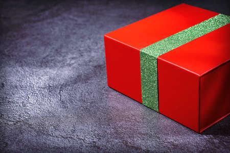 Red gift box with a green ribbon on a gray marble background. View from aboveの写真素材