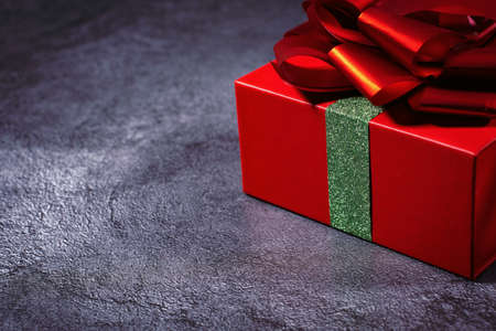 box with ribbon and red bow isolated on gray backgroundの写真素材