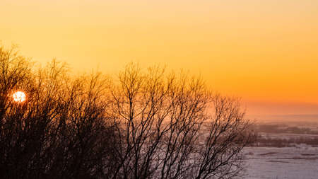 Beautiful sunset with clouds over a snowy plain and river bendの写真素材