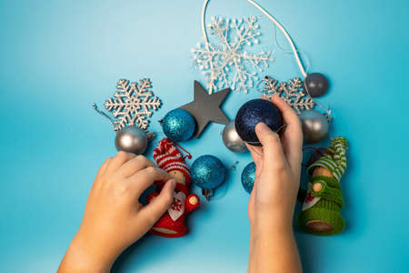 Christmas background with the hands of a child preparing New Year's decorations. View from above. The concept of preparing for the New Year holidays.の写真素材