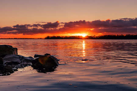 Beautiful sunset over the river with large rocks in the foreground. Autumn landscapesの写真素材