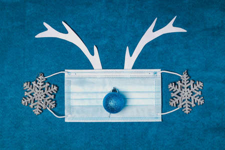 Festive Christmas background with deer antlers, medical face mask and decorations. New Year 2021の写真素材