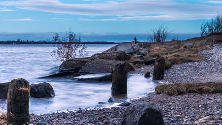 Beautiful morning landscape with a river and a bank strewn with stones. Autumn season. Blurry water effectの写真素材