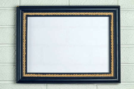 Empty old frame in blue on a white brick wall background. Copy space.の写真素材