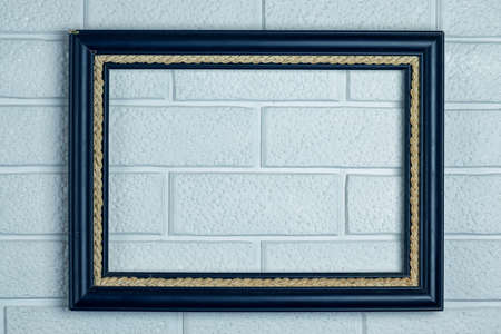 Empty old frame in blue on a white brick wall background. Copy space.の写真素材