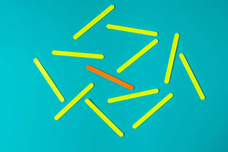 A prominent orange object in a group of identical yellow objects.の写真素材