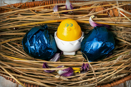 Easter eggs on straw in a wicker basket close-up. Flat lay.の写真素材