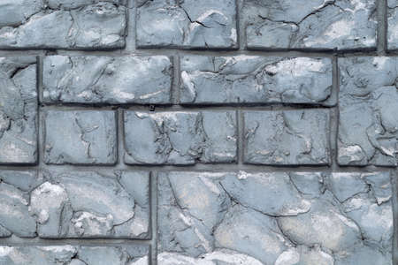 Background texture of an old wall under a natural gray stone in the form of brickwork. Decorative finishing of buildings.の写真素材