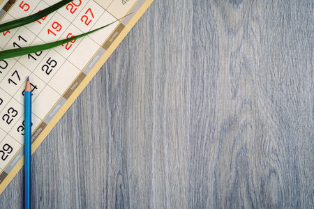 Calendar sheet, palm leaf and pencil on wood table texture. Planningの写真素材
