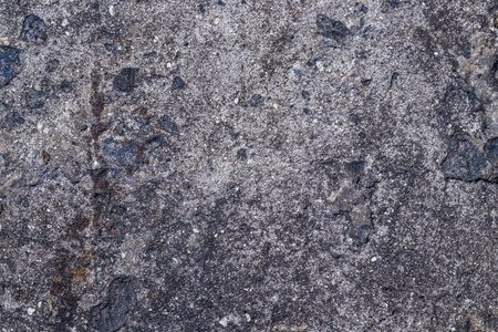 Background texture of an old concrete wall interspersed with black stones. Copy spaceの写真素材