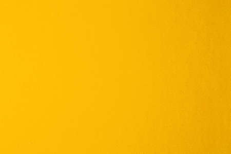 Background texture of a blank sheet of yellow paper.の写真素材