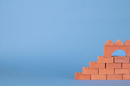 Rows of red bricks close-up on a blue-gray background. Unfinished wall.の写真素材