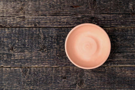 Empty bowl of white clay on an old wooden table surface. Copy spaceの写真素材