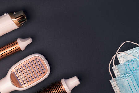Hairdresser tools and medical protective masks on dark background.の写真素材