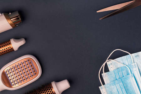 Hairdresser tools and medical protective masks on dark background.の写真素材