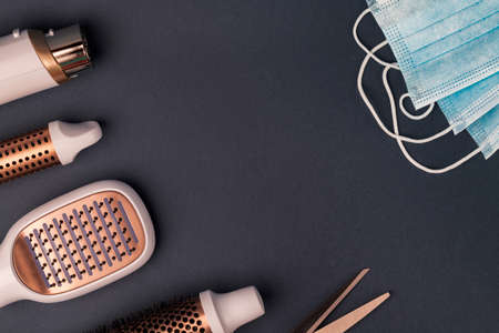 Hairdresser tools and medical protective masks on dark background.の写真素材