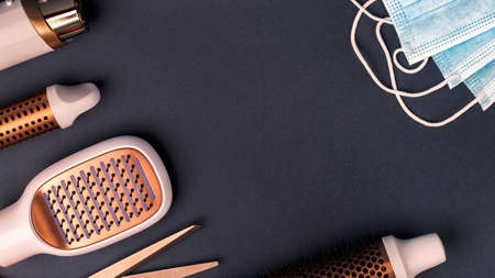 Hairdresser tools and medical protective masks on dark background.の写真素材