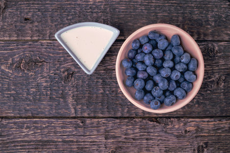 Bowl with blueberries and yogurt on a background of an old wooden surface.の写真素材